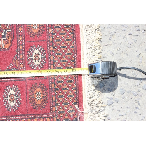 203 - A small red ground rug with gul