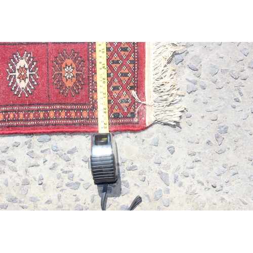 203 - A small red ground rug with gul