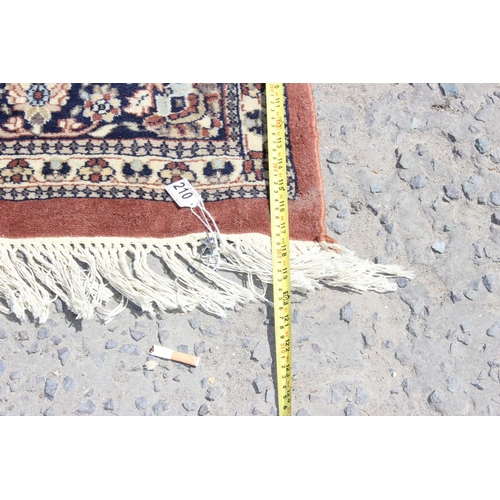 210 - A large rug with central medallion and arabesque border