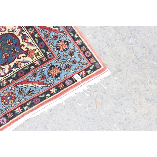 211 - A modern blue and red ground rug central medallion and arabesque border