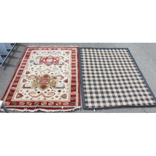 214 - A cream and red ground rug and a black and white squares rug