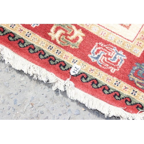 214 - A cream and red ground rug and a black and white squares rug