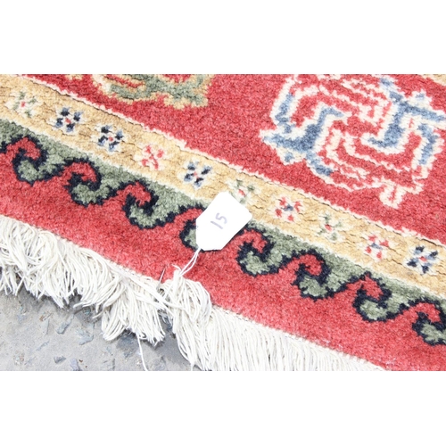214 - A cream and red ground rug and a black and white squares rug