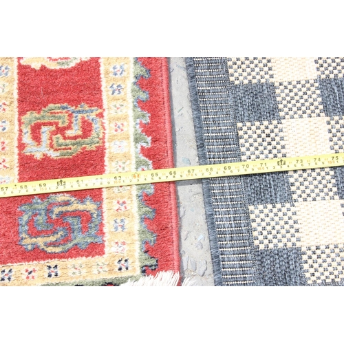 214 - A cream and red ground rug and a black and white squares rug