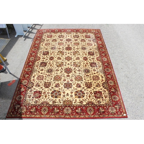 216 - A large Keshan Adoros wool rug of red and cream ground