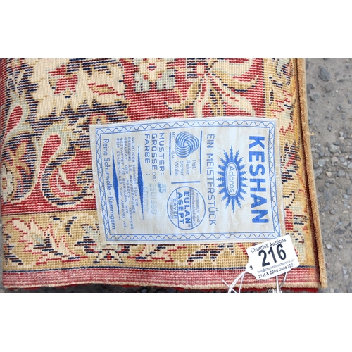 216 - A large Keshan Adoros wool rug of red and cream ground