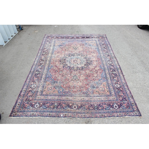 217 - A large antique red and blue ground rug with profuse decoration