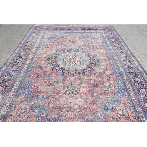 217 - A large antique red and blue ground rug with profuse decoration