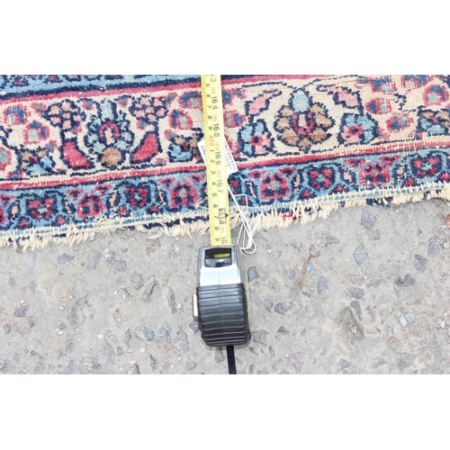 217 - A large antique red and blue ground rug with profuse decoration