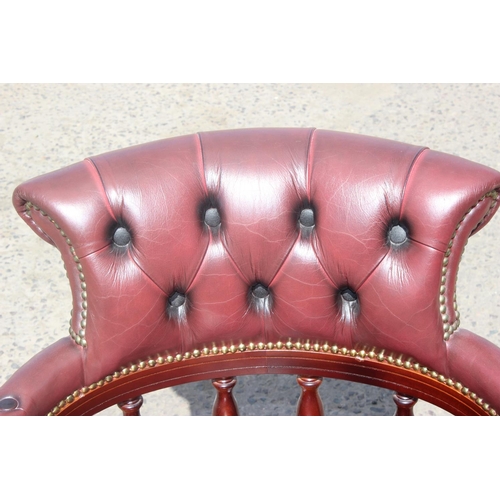 1 - A captain's swivel or desk chair in Ox Blood red leather with Chesterfield button back