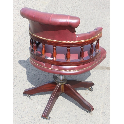 1 - A captain's swivel or desk chair in Ox Blood red leather with Chesterfield button back