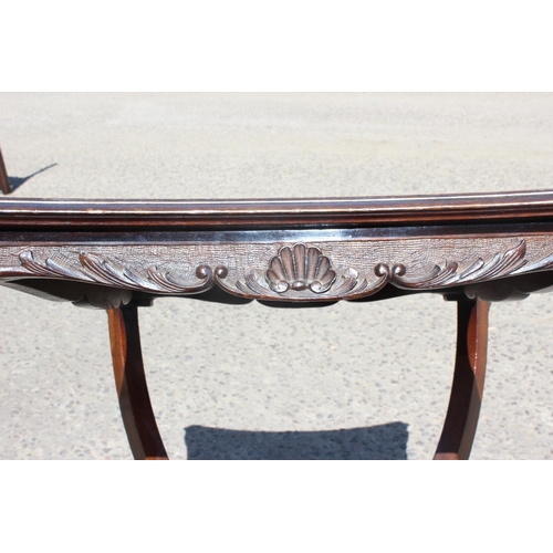 53 - An Edwardian table of unusual form with carved details and brass gallery to base