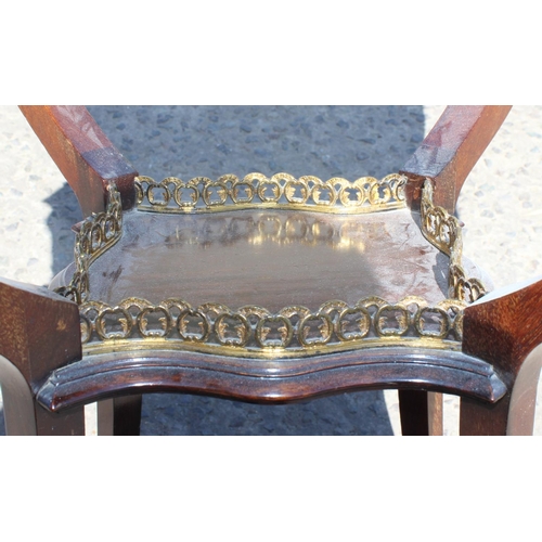 53 - An Edwardian table of unusual form with carved details and brass gallery to base