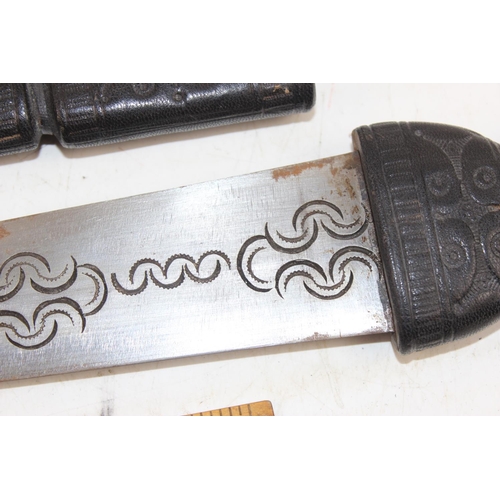 1027 - Leather covered ethnic sword in sheath