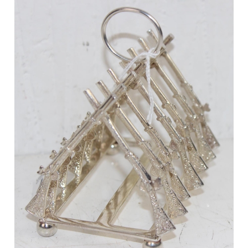 1107 - A 20th century silver plated toast rack formed as crossed rifles