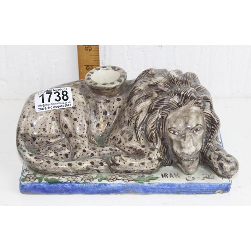 1738 - An unusual tin glazed pottery figure of a recumbent lion formed as a candlestick - marked Iran and A... 