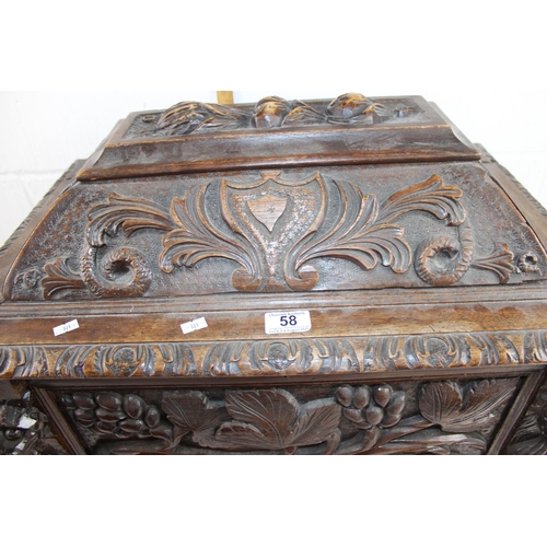 58 - An unusual carved Oak cellarette of sarcophagus form decorated with carved oak lion masks and foliag... 