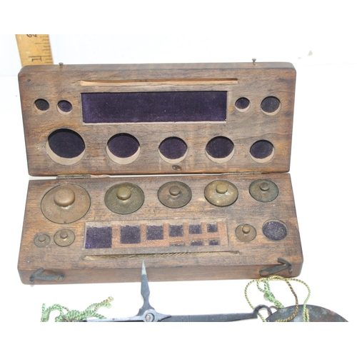 603 - A wooden boxed set of scientific weights and a pair of balance scales