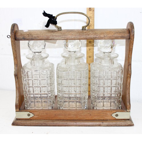 1677 - An early 20th century Oak & silver plate framed 3 bottle Tantalus with working lock and key