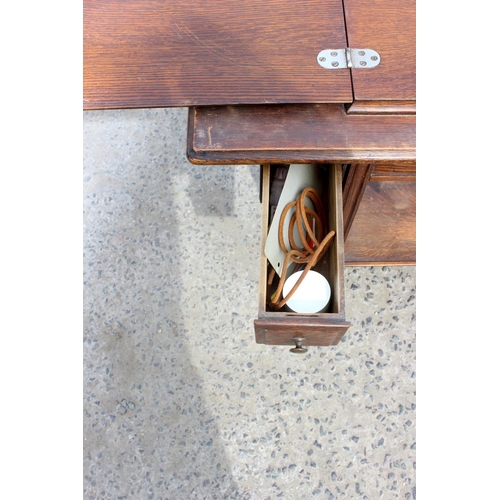 138 - Antique Oak sewing table containing a Jones sewing machine