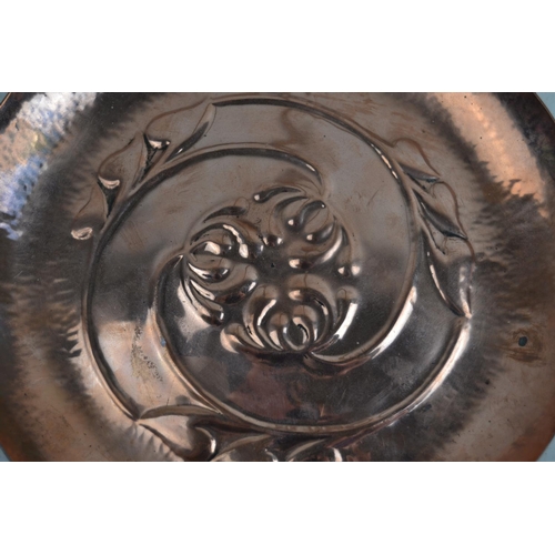 1670 - An Art Nouveau copper dish with embossed decoration in the style of Keswick