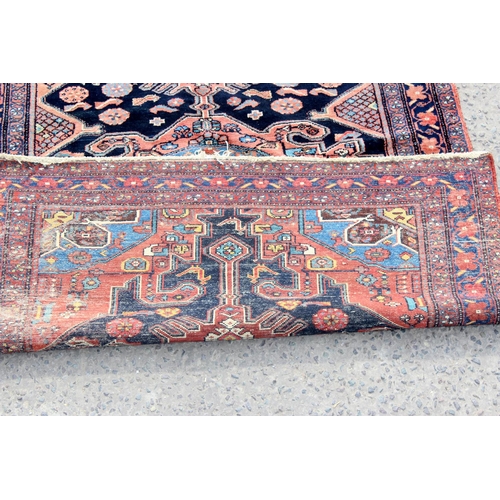 208 - A large vintage red ground rug with central medallion and floral border