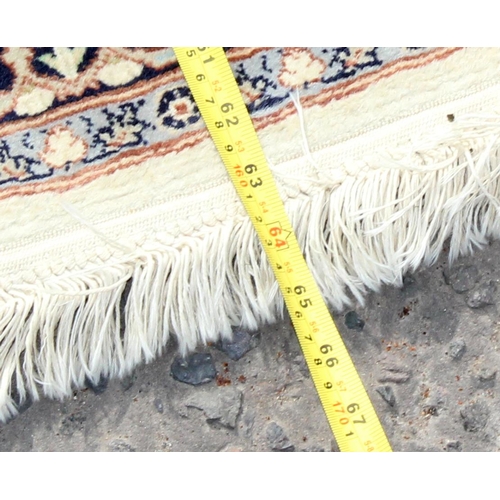 211 - A good quality cream ground rug with central medallion and arabesque border - high knot count