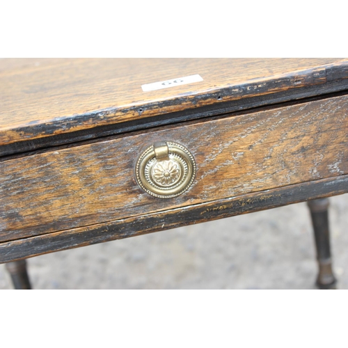 66 - A small antique oak side table with bamboo effect legs and brass and ceramic casters