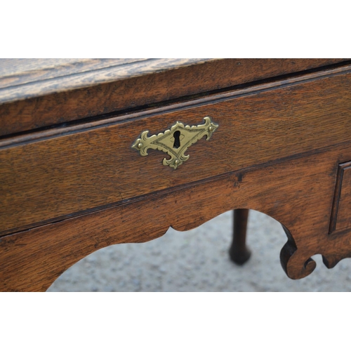 1 - A Georgian oak lowboy with one long drawer over 2 smaller drawers, all with brass fittings, standing... 