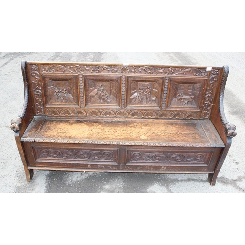 89 - Antique carved oak settle profusely carved with masks and foliage, 4 carved back panels depicting a ... 