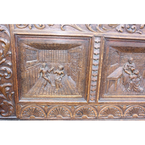 89 - Antique carved oak settle profusely carved with masks and foliage, 4 carved back panels depicting a ... 