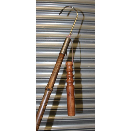An antique, two part game fishing gaff with brass and steel ferrules on a  bamboo shaft. The gaff, fu
