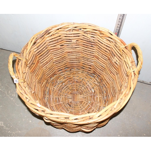 107 - An extremely large vintage wicker log basket with handles, approx 31 inches in diameter and 30 inche... 