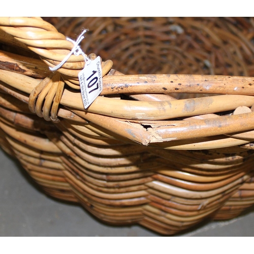 107 - An extremely large vintage wicker log basket with handles, approx 31 inches in diameter and 30 inche... 