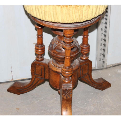 25 - A Victorian mahogany piano stool with screw adjusting top and gold coloured upholstery