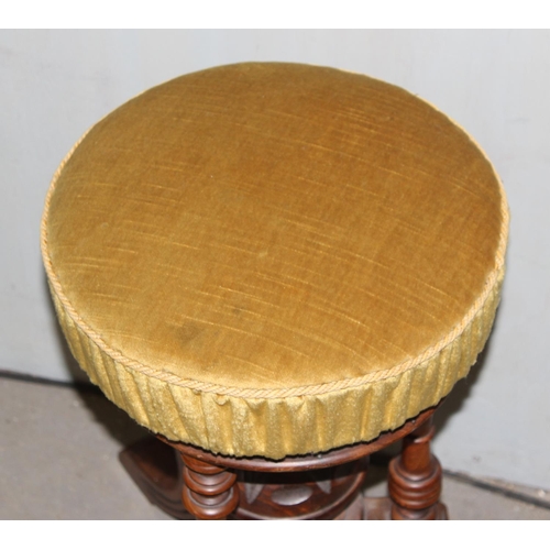 25 - A Victorian mahogany piano stool with screw adjusting top and gold coloured upholstery