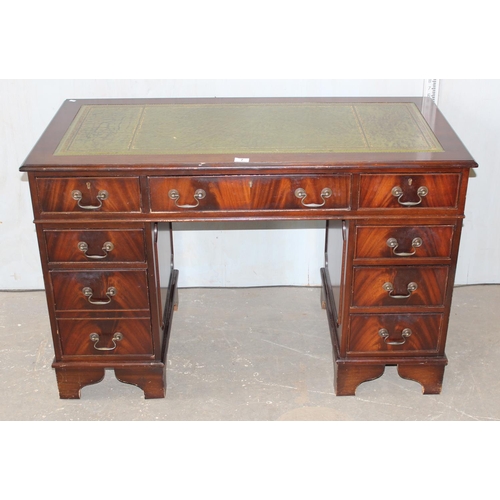 7 - A reproduction mahogany desk with green leather top and key