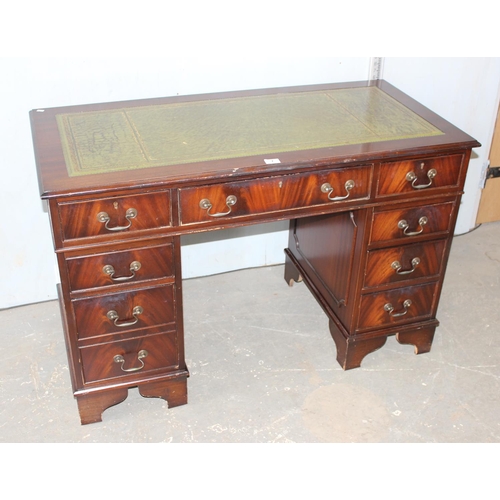 7 - A reproduction mahogany desk with green leather top and key