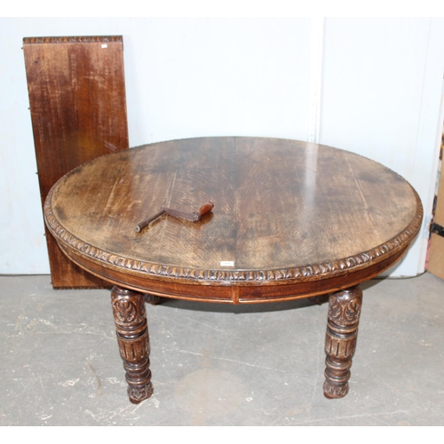 99 - A large antique carved oak dining table on impressive carved legs, extra leaf and original winder