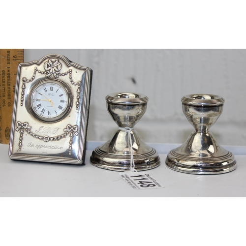 1148 - A modern silver mounted desk clock and a pair of dwarf silver candlesticks, Birmingham 1971