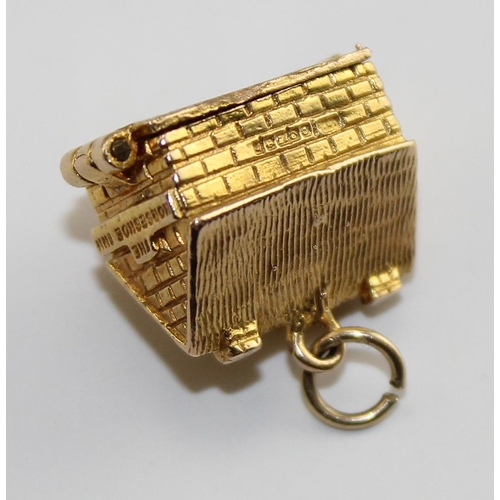 1220 - A 9ct gold charm of a house, opens to reveal a scene of domestic life, approx 4.61g gross weight