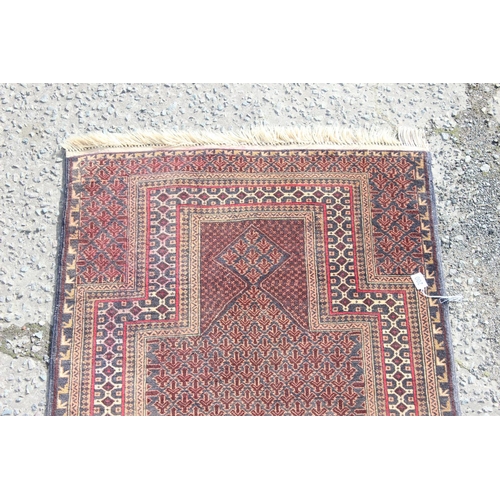 200 - A vintage handmade prayer rug with geometric design, approx 140cm x 90cm, import label verso
