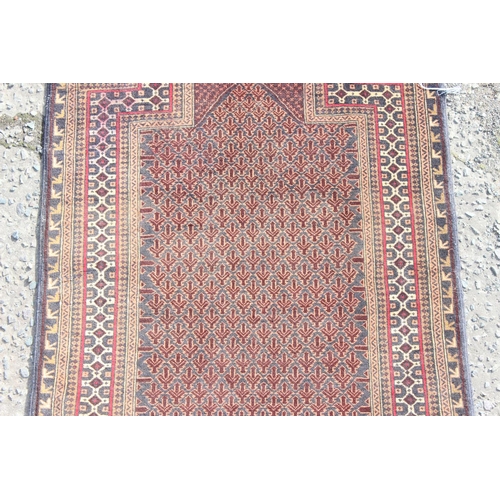 200 - A vintage handmade prayer rug with geometric design, approx 140cm x 90cm, import label verso