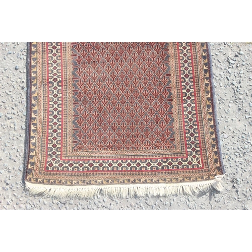 200 - A vintage handmade prayer rug with geometric design, approx 140cm x 90cm, import label verso