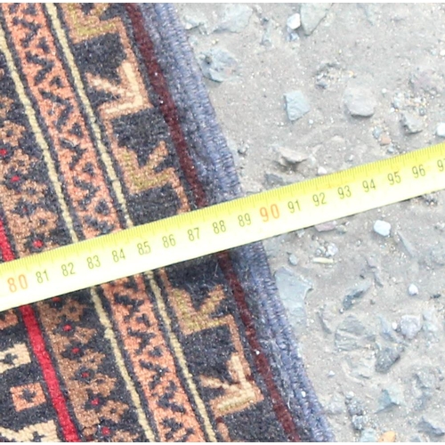 200 - A vintage handmade prayer rug with geometric design, approx 140cm x 90cm, import label verso