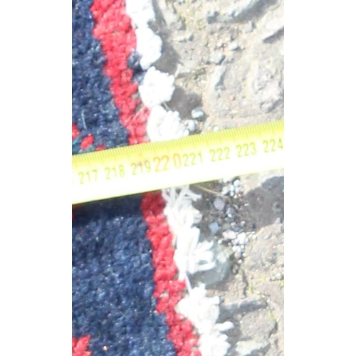 201 - A vintage handmade red & blue ground rug with central medallion, approx 220cm x 163cm