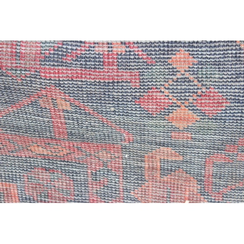 201 - A vintage handmade red & blue ground rug with central medallion, approx 220cm x 163cm