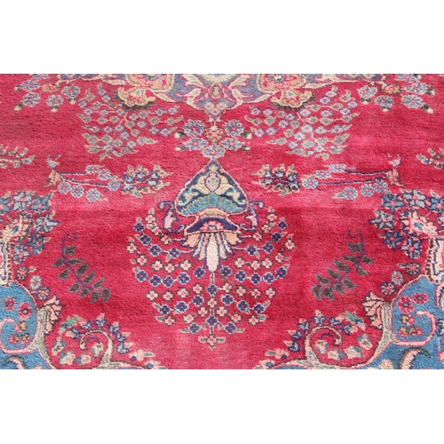 202 - A large Persian handmade rug of red ground with large central medallion, labelled verso, approx 309c... 