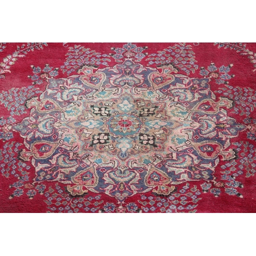 202 - A large Persian handmade rug of red ground with large central medallion, labelled verso, approx 309c... 