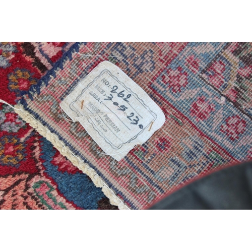 202 - A large Persian handmade rug of red ground with large central medallion, labelled verso, approx 309c... 